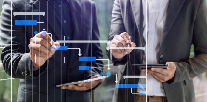 Project manager working and update tasks with milestones progress planning and Gantt chart scheduling diagram. business working with smart phone, tablet and laptop in office.